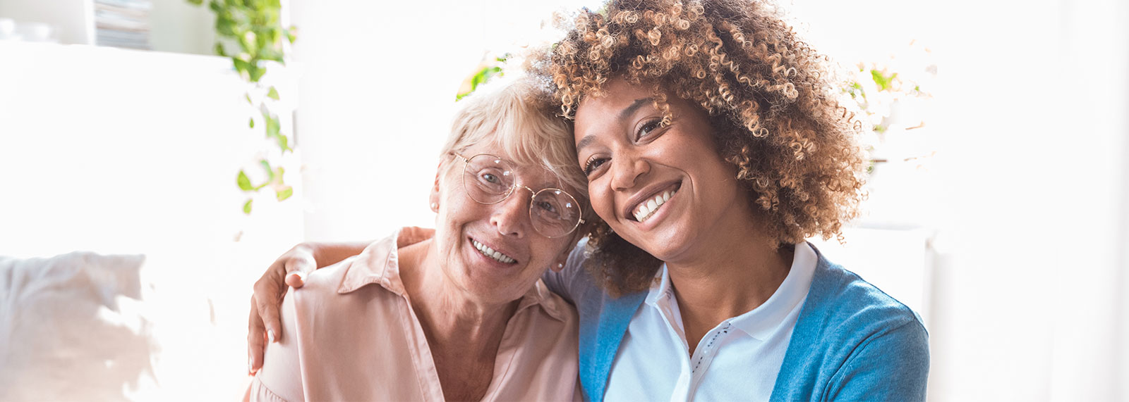 Female caregiver with her arm around senior woman's shoulders